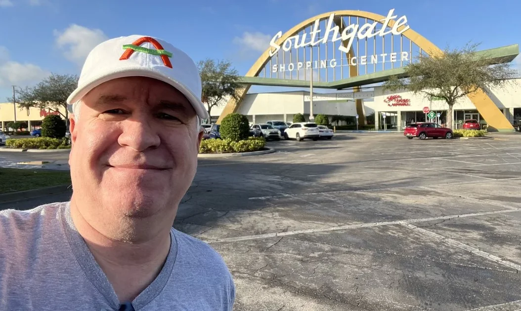 Don Burns in an I Am Love cap in front of the Southgate Shopping Center arch, Lakeland